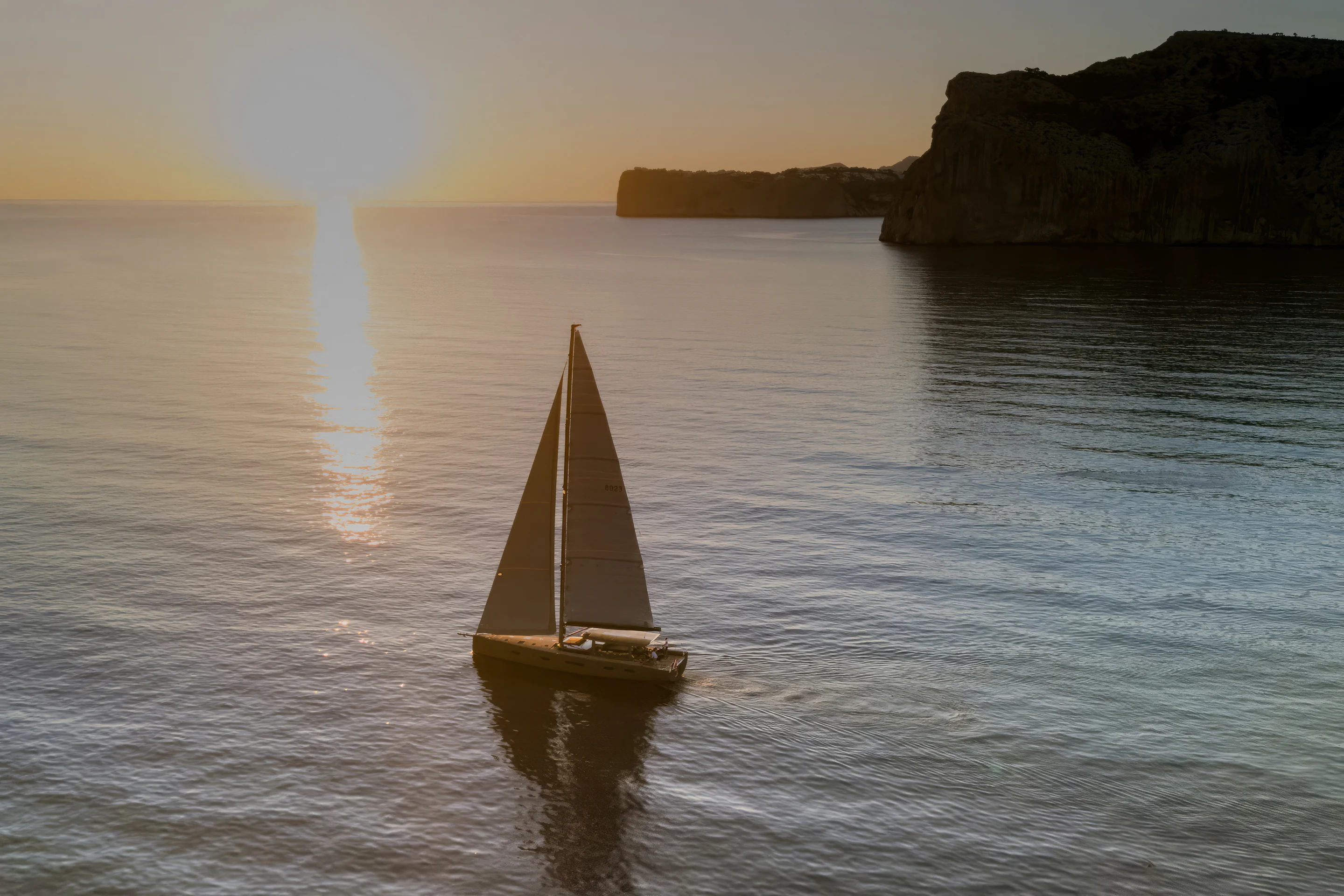 Sailing Yacht W under sail at golden hour, a carbon race cruiser